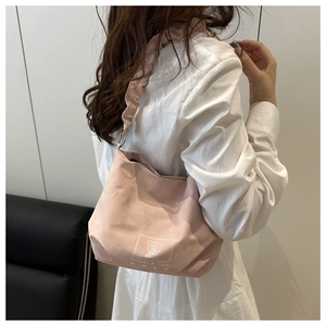Detail of pink matte shoulder bag featuring soft pleats and Altumi bear logo print