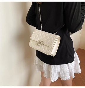 Sac bandoulière matelassé blanc crème avec boucle noeud argentée et bandoulière