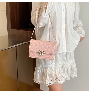 Détail du sac à bandoulière matelassé rose avec boucle nœud argenté et chaîne métal