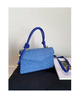 Detail view of blue denim texture canvas bag with unique rope knot handle and PU leather trim