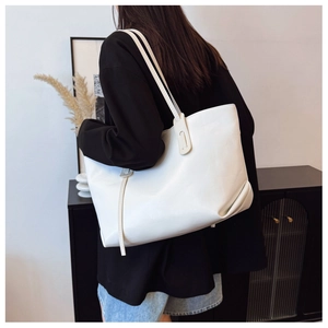 Minimalist white leather tote bag shown on model back in a modern home interior