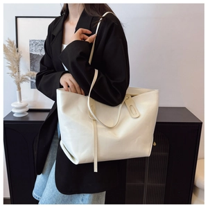 Detail of cream white tote bag with soft leather texture and long shoulder straps