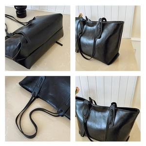 Detail view of black tote bag showing PU leather texture and durable bottom stitching