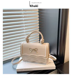 Détail du sac kaki avec décoration de nœud en métal et bords plissés ondulés élégants