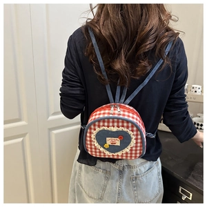 Detail of red and white checkered mini backpack with heart denim patch and lace trim
