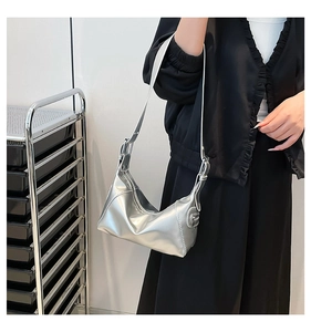 Detail of silver metallic crescent bag with adjustable strap and sleek stitching finish