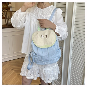 Detail of blue pear shaped backpack with cartoon embroidery and Pear logo text