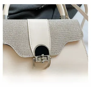 Close-up of off-white PU handbag with rhinestone-encrusted flap and metal buckle