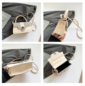 Macro view of beige leather handbag featuring a glitter flap and silver metal horse-bit buckle