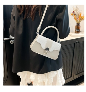 Detail of light gray mini box handbag with silver glitter flap and metal clasp
