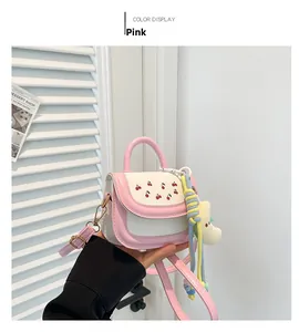Detail of pink and white mini crossbody bag with cherry prints and star pendant
