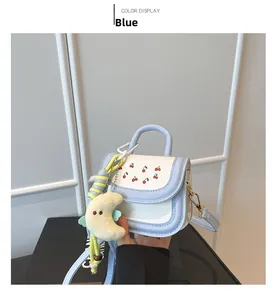 Detail of blue and white mini bag with cherry print and moon plush keychain