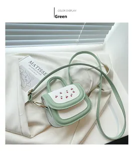 Detailed shot of green and white mini bag with cherry print and leather texture