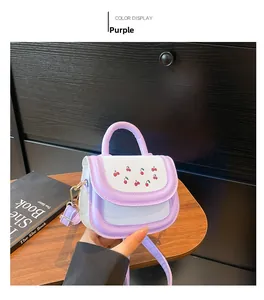 Detail of a purple and white mini crossbody bag featuring a cute red cherry pattern