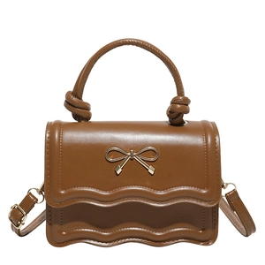 Sac bandoulière en cuir marron avec nœud doré et poignée tressée sur fond blanc
