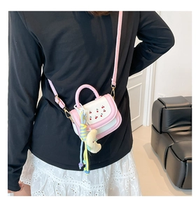 Détail du sac bandoulière rose et blanc avec broderie cerise et pendentif lune
