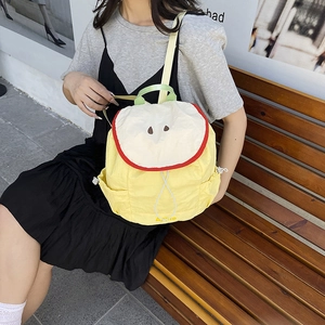 Japanese style yellow apple-shaped backpack with large capacity for students on a bench