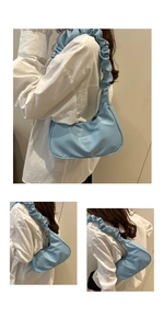 Detail of light blue pleated cloud shoulder bag with matte faux leather and half-moon shape
