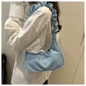 Detail of light blue hobo bag with unique scrunchie handle and minimalist half-moon shape