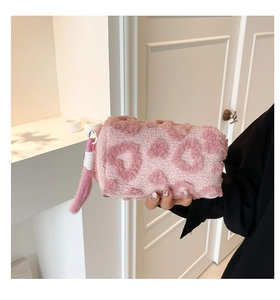 Detalle de neceser rosa de lana sintética con corazón de peluche y correa de mano