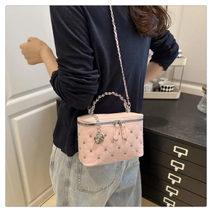 Close-up of pink quilted crossbody bag with silver studs and rose pendant detail