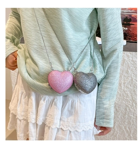Detail of glitter heart cross-body bags in pink and silver with metal chain straps
