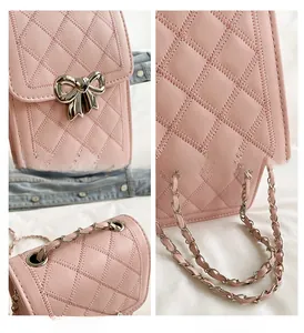 Detail of pink quilted leather phone bag featuring silver bow clasp and chain strap