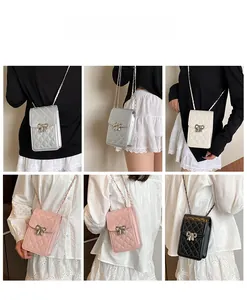 Close-up of diamond quilted crossbody phone bag with polished metal bow clasp