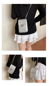 Close-up of silver quilted mini crossbody bag with a delicate metallic bow detail