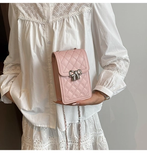 Close-up of pink quilted mini crossbody bag with silver bow clasp and chain strap