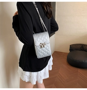 Silver quilted phone crossbody bag with metal bow buckle and elegant chain strap details
