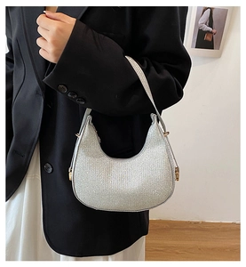 Détail du sac hobo argenté scintillant en forme de lune avec boucles dorées