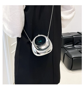 Detail of silver pebble-shaped acrylic evening bag with a metal chain crossbody strap