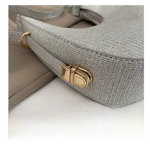 Détail du sac argenté pailleté avec des finitions métalliques dorées de haute qualité