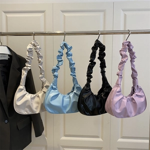 Minimalist moon-shaped pleat bags in white, blue, black, and purple with scrunchie handles