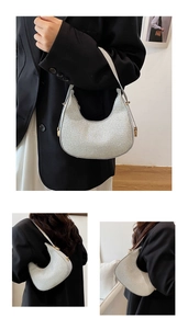 Detail of silver sequined crescent hobo bag featuring golden metal buckles and slim strap