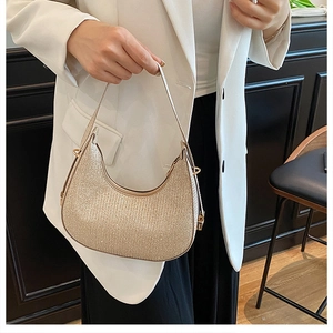 Detail of champagne gold hobo bag featuring shimmering metallic texture and zipper