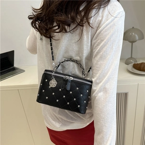Quilted black mini chain box bag with silver studs and rose pendant on shoulder strap