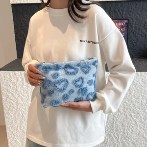 Light blue plush heart makeup bag with soft fleece texture and cute handheld design