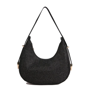 Sac hobo minimaliste à paillettes noires avec boucles dorées sur un fond blanc neutre