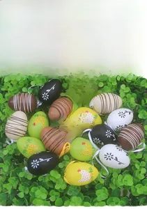 Detail of colorful Easter eggs with festive patterns and hanging strings on green foliage