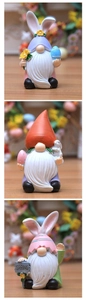 Tre statuine di gnomi pasquali con orecchie da coniglio su sfondo in legno chiaro