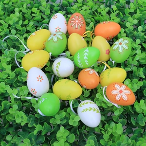 Colorful Easter egg ornaments with floral patterns and hanging ribbons on green grass