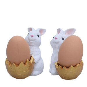 Easter bunny figurines in golden eggshells, white resin holiday decor for festive tables