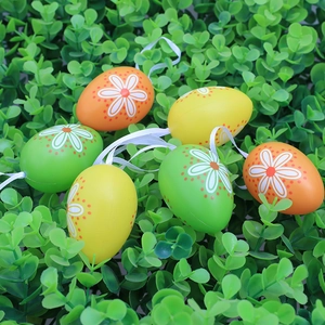 Set of 6 colorful Easter eggs with daisy patterns and ribbons on green leaf background