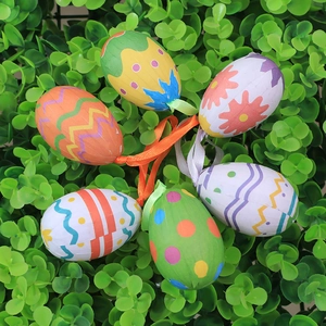 Set of 6 decorative Easter eggs with colorful patterns and ribbons on green foliage