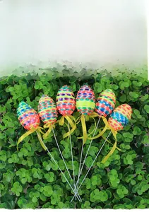 Detailed view of six colorful woven Easter eggs with ribbon bows on long white stems