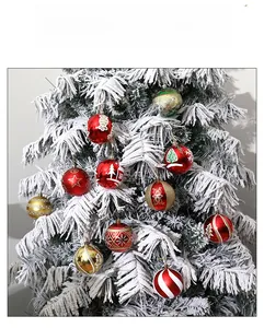 Close-up of 8cm decorative Christmas balls with glitter patterns on snowy tree branch