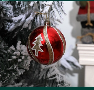 Detail of red Christmas ball with gold stripes and white tree patterns on a tree