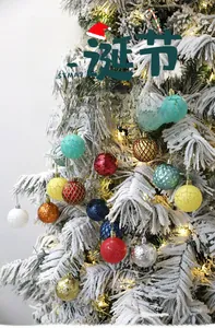 Close-up of decorative Christmas tree ball ornaments with various patterns on snowy branches